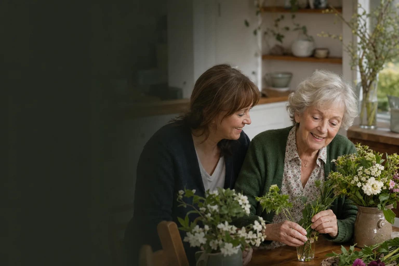 An older woman and her Care Giver enjoying arranging fresh flowers together at home