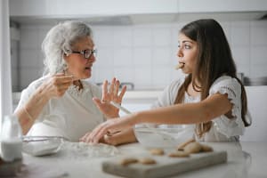 Young Homecare Giver helping an older lady bake, supporting her with her hobbies.